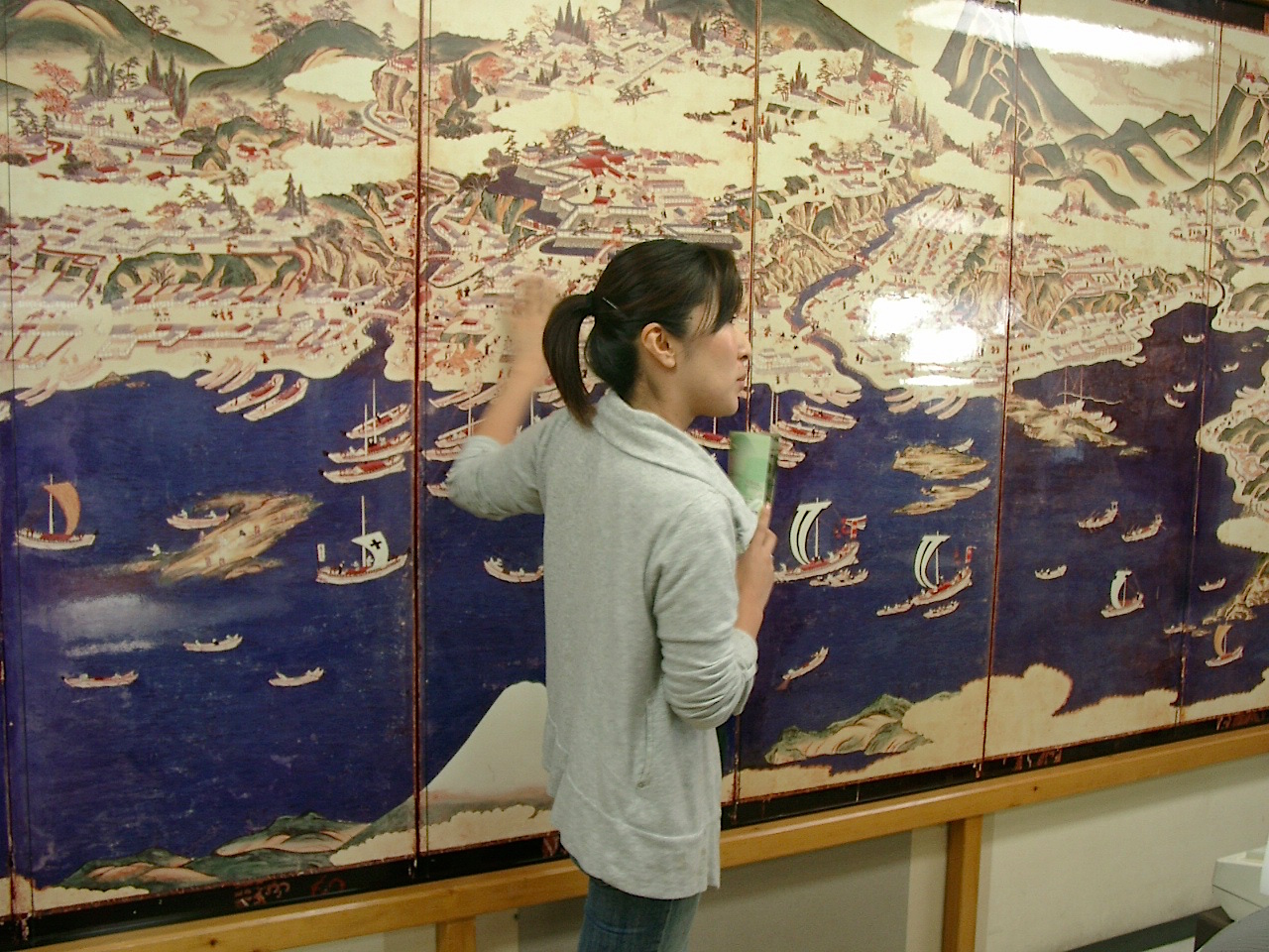 温泉旅館矢野に展示される松前屏風図(レプリカ)を解説する若女将の杉本夏子さん
